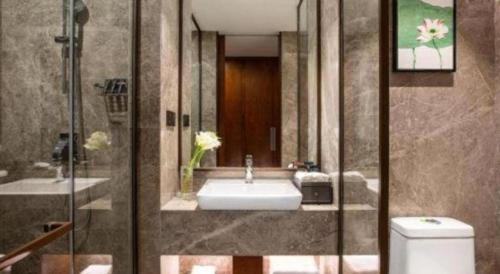 Ramada Encore by Wyndham Wuhan Caidian في ووهان: حمام مع حوض ودش ومرحاض