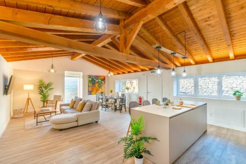 Una cocina y sala de estar con techos de madera. en Espectacular apartamento a 10 minutos de Pamplona, en Uterga