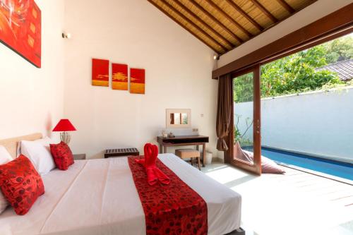 1 dormitorio con cama blanca y almohadas rojas en Little Coco Gili Trawangan Hotel, en Gili Trawangan