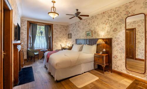 una habitación de hotel con una cama y un espejo en Rokeby Manor, en Invergarry