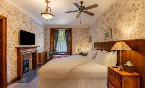 Un dormitorio con una cama grande y una chimenea. en Rokeby Manor, en Invergarry