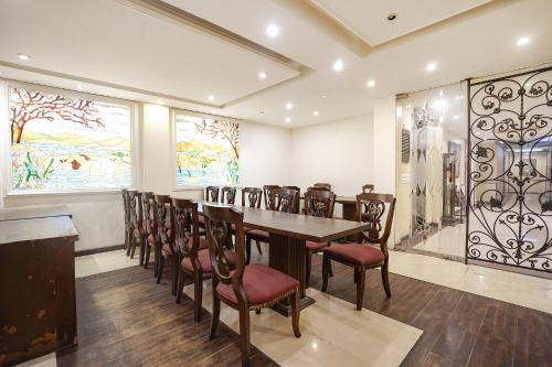 Un comedor con una mesa larga y sillas. en FabHotel NFC Royale, en Nueva Delhi