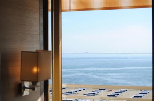 a room with a view of the ocean from a window at Hotel Capri & Residence in Lido di Camaiore