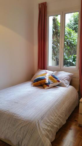 - un lit avec deux oreillers assis à côté d'une fenêtre dans l'établissement Nice Promenade Apartment, à Nice