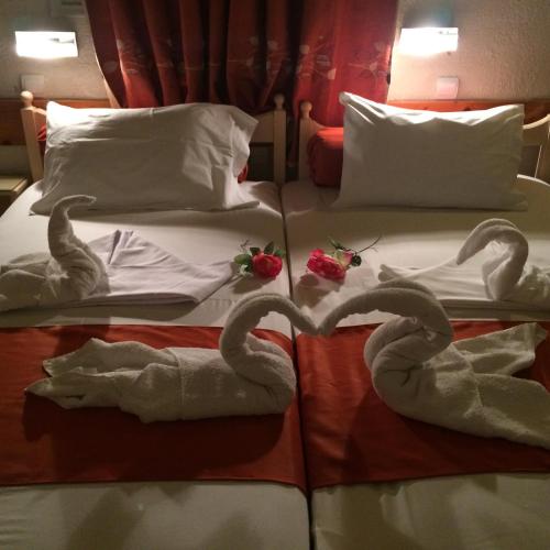 two swans made out of towels on a bed at Alkyonis Apartments in Panormos Kalymnos