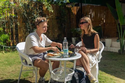 a man and woman sitting at a table eating food at TLO - The Life Outdoor, Bir Billing in Bīr