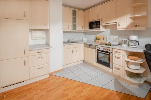 una cucina con elettrodomestici bianchi e armadietti in legno di Haus Sanderling Meeresbrise a Loog