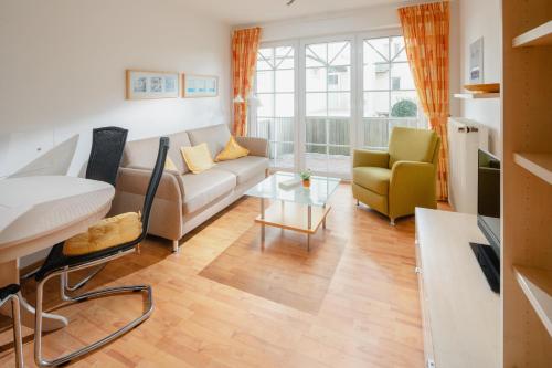 un soggiorno con un divano e un tavolo di Haus Sanderling Meeresbrise a Loog