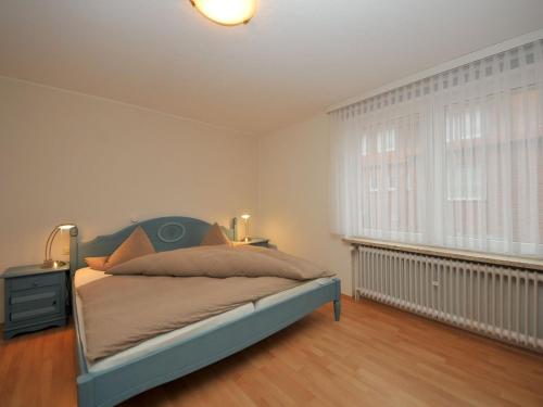 a bedroom with a bed and a window at Haus Nixe Stranddüne in Juist