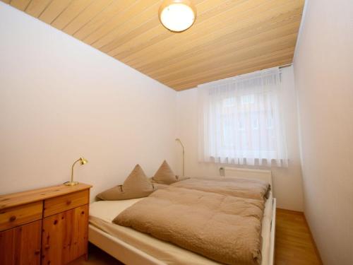a bedroom with a bed and a wooden ceiling at Haus Nixe Kachelot in Juist