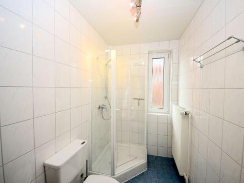 a white bathroom with a shower and a toilet at Haus Nixe Kachelot in Juist