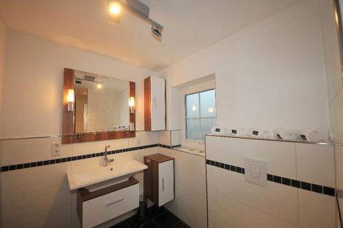 a bathroom with a sink and a mirror at ENA Ferien Strandhütte in Juist
