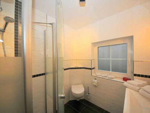 a bathroom with a toilet and a window at ENA Ferien Strandkiste in Juist