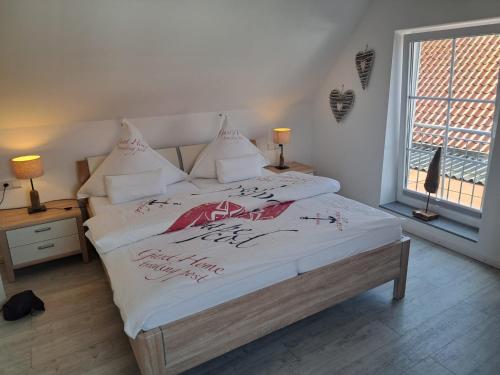 a bedroom with a bed with writing on it at ENA Ferien Strandloft in Juist