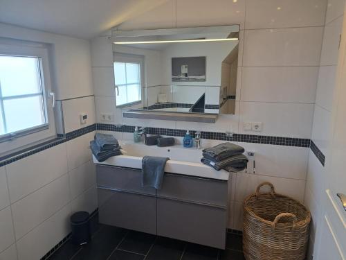 a bathroom with a sink and a mirror at ENA Ferien Strandloft in Juist