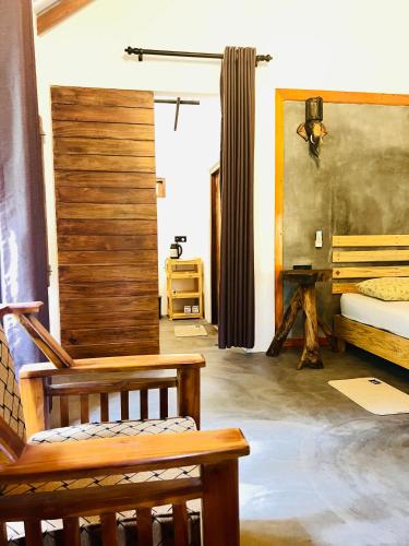 a room with a bed and a bench in it at Sigiriya Coconut Shade Resort in Sigiriya