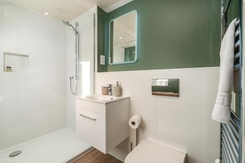 a bathroom with a toilet and a sink and a mirror at Garsington Studios Chilterns Farm House - Pass the Keys in Stokenchurch
