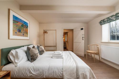 a bedroom with a white bed with a green headboard at Garsington Studios Chilterns Farm House - Pass the Keys in Stokenchurch