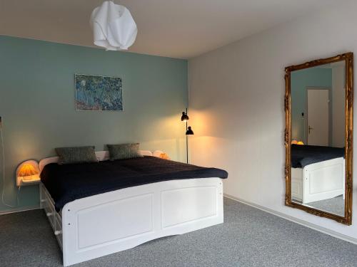 ein Schlafzimmer mit einem weißen Bett und einem Spiegel in der Unterkunft Vestergade appartement in Tønder