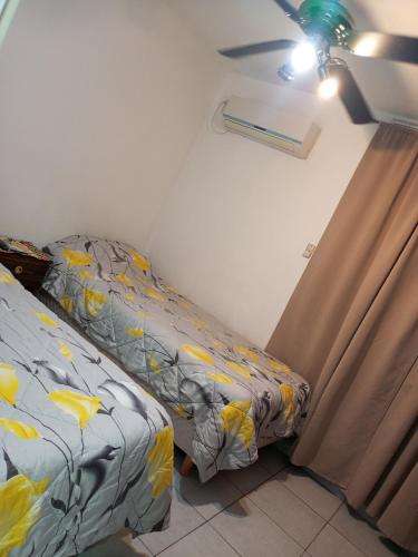 a bedroom with two beds and a curtain and a window at Departamento el estadio in Santiago del Estero