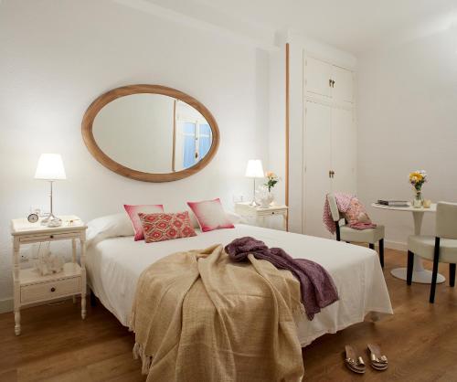 1 dormitorio con cama y espejo en la pared en Lodgingmalaga Cristo de la Epidemia, en Málaga