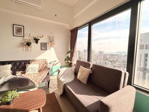 a living room with a couch and a large window at Tropicana 218 Macalister #Top Floor #WideAngleViews #InfinityPool #Georgetown #8pax #3BR 2bath #2Queen 4Single #Near island hospital #Quality well maintained #Private host in George Town