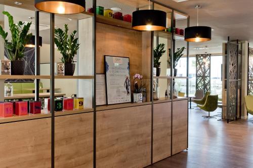 a lobby with a wooden partition with potted plants at Super 8 by Wyndham Munich City North in Munich