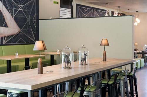 a table in a restaurant with chairs and wine glasses at Super 8 by Wyndham Munich City North in Munich
