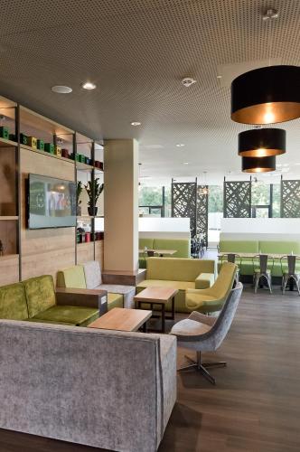 a lobby with couches and chairs and tables at Super 8 by Wyndham Munich City North in Munich