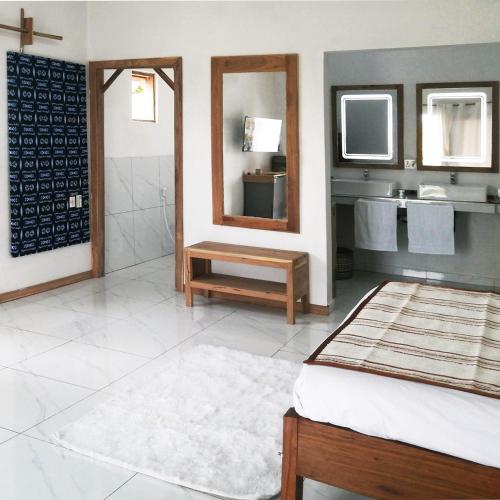 a bathroom with a bed and a sink and a mirror at Duna Serena Tiny Houses in Praia do Tofo