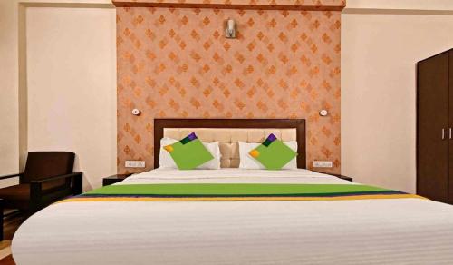 Un dormitorio con una cama grande con almohadas verdes. en Jaipur Grand Bella, en Jaipur