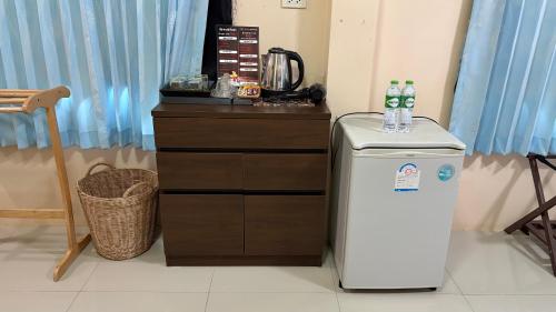 een kamer met een koelkast en een aanrecht met waterflessen bij ChefJa Hotel and Restaurant 