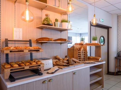 a bakery with lots of loaves of bread and pastries at Residhome Toulouse Occitania in Toulouse