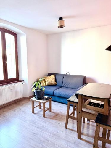 a living room with a blue couch and a table at T2 centre Ville Proche des pistes in Briançon