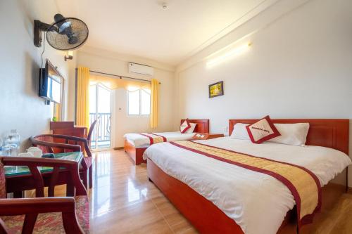 Hoàng Hà Hotel Tam Đảo في تام داو: غرفة فندقية تحتوي على سريرين وطاولة وكراسي