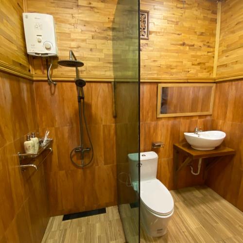 a bathroom with a shower and a toilet and a sink at Bagas Luxury Camp in Kejajar