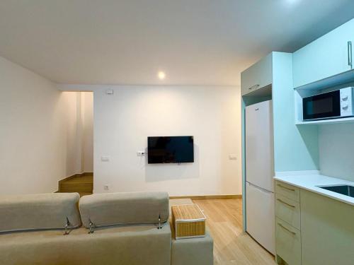 a living room with a couch and a flat screen tv at Hauzify I Can Xasil in Blanes