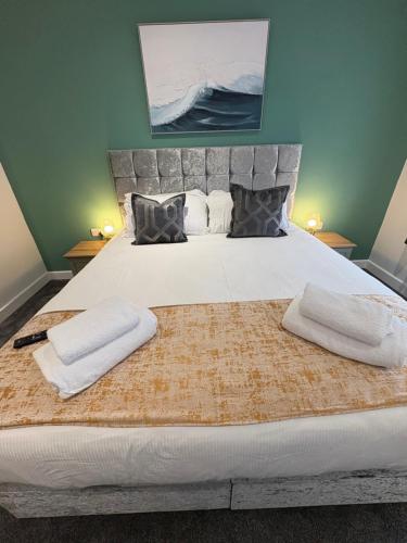 a bedroom with a large bed with two towels on it at Cleveleys Town Centre in Blackpool