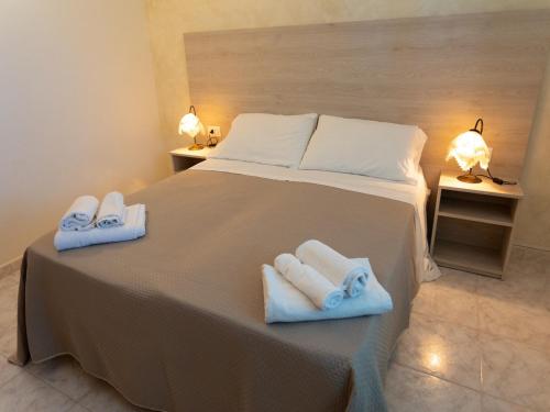 Un dormitorio con una cama grande con toallas. en San Domenico Village, en Fitili