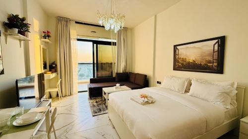 a bedroom with a large bed and a living room at Petalz Luxury furnished studio with Balcony Swimming Pool Gym Kids play ground in Dubai
