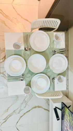 a table with plates and utensils on a counter at Petalz Luxury furnished studio with Balcony Swimming Pool Gym Kids play ground in Dubai