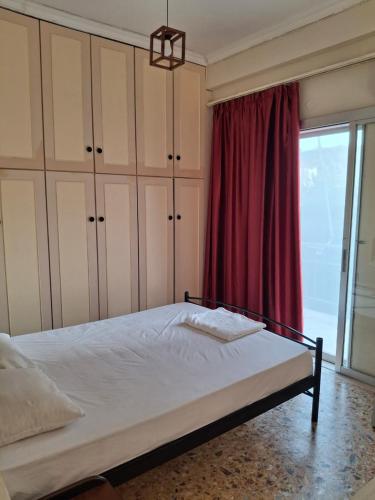 ein Schlafzimmer mit einem Bett mit einem roten Vorhang in der Unterkunft Eunoé House in Kakí Vígla