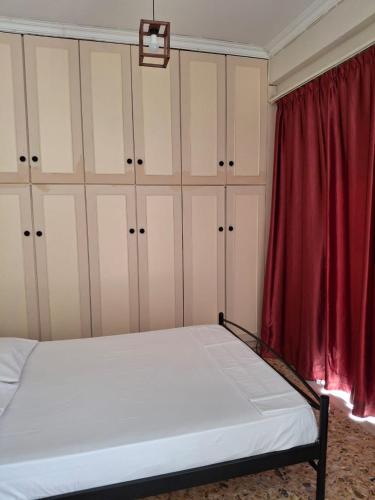 ein Schlafzimmer mit einem Bett und einem roten Vorhang in der Unterkunft Eunoé House in Kakí Vígla