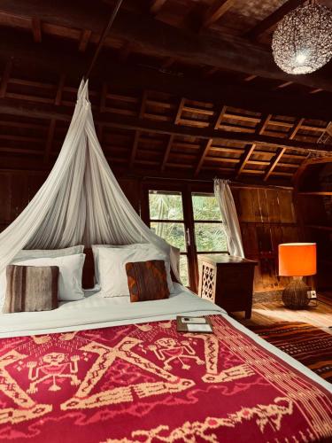 a bedroom with a large bed with a mosquito net at Resort JUNGLEROOM Canggu in Canggu