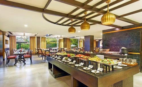a buffet line in a restaurant with tables and chairs at Luxury Aloha Apartments, Rishikesh in Rishīkesh