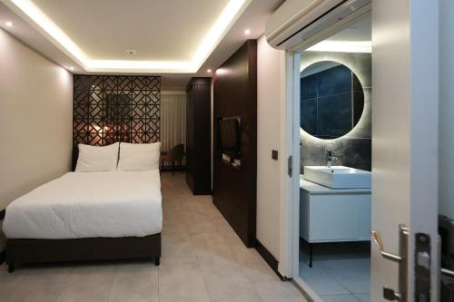 a bedroom with a bed and a bathroom with a sink at Visse Hotel in Mudanya
