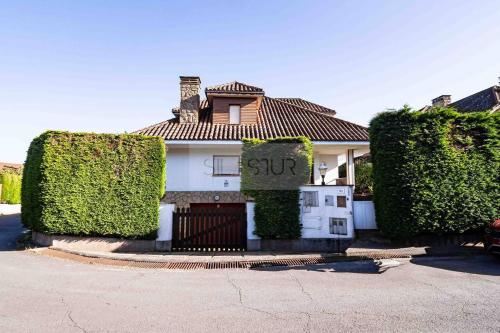 a white house with a sign in front of it at Casa Costera Gijón By Silastur in Gijón