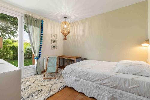 een slaapkamer met een bed, een tafel en een raam bij Beautiful air-conditioned house and heated pool in La Celle-sous-Gouzon