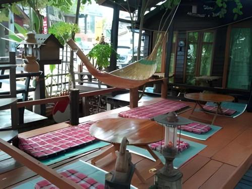 a hammock in a room with tables and chairs at P&P Coffee & Resort Maesariang in Ban Kat