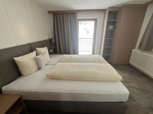 a hotel room with two beds and a window at Nonas B&B in Galtür